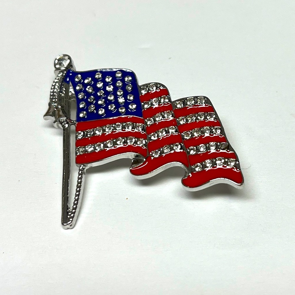 Brooch- American Flag, NIP, rhinestones, & enamel paint, a silver base, 1.5x1.5”
